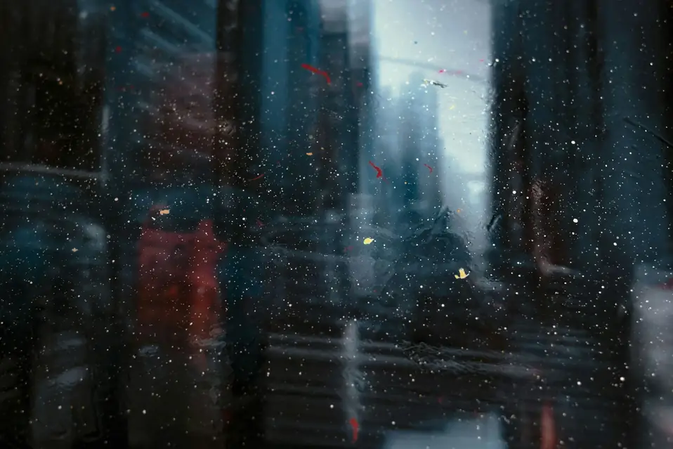 Blurred city lights through a rain-speckled window, suggesting unclear inventory numbers during a Shopify flash sale